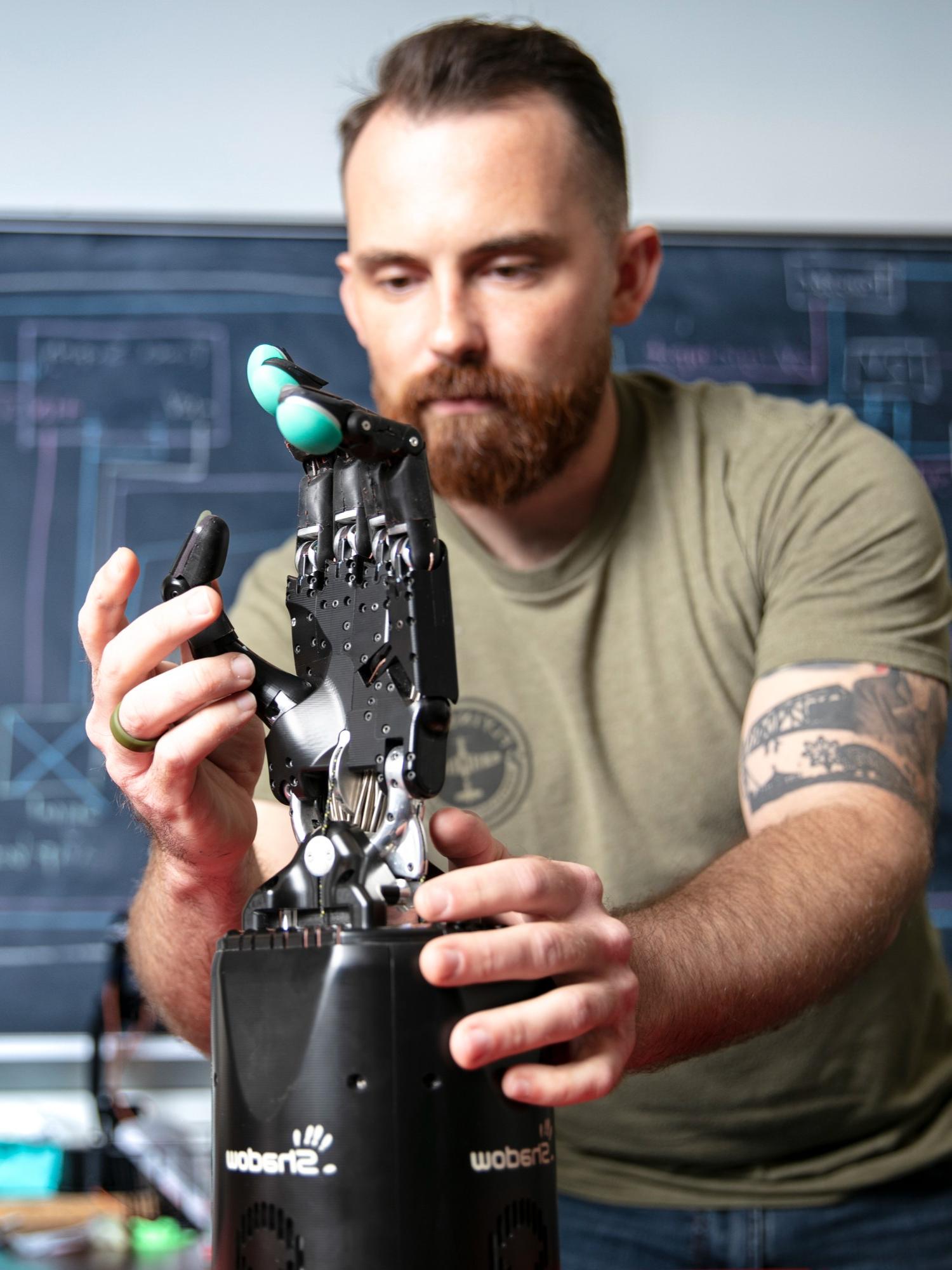 man studying robotic hand