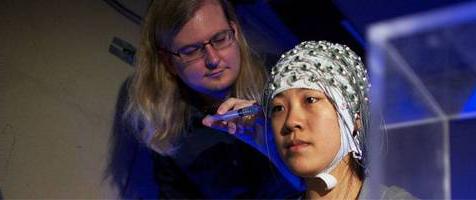 woman wearing brain scanner while being examined